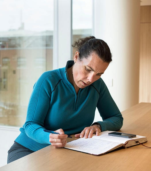 La mujer está escribiendo en un diario