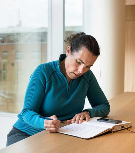 La mujer está escribiendo en un diario